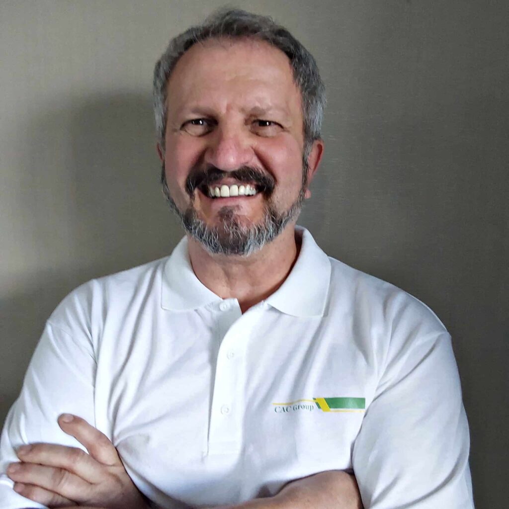 Smiling man in white polo shirt with crossed arms