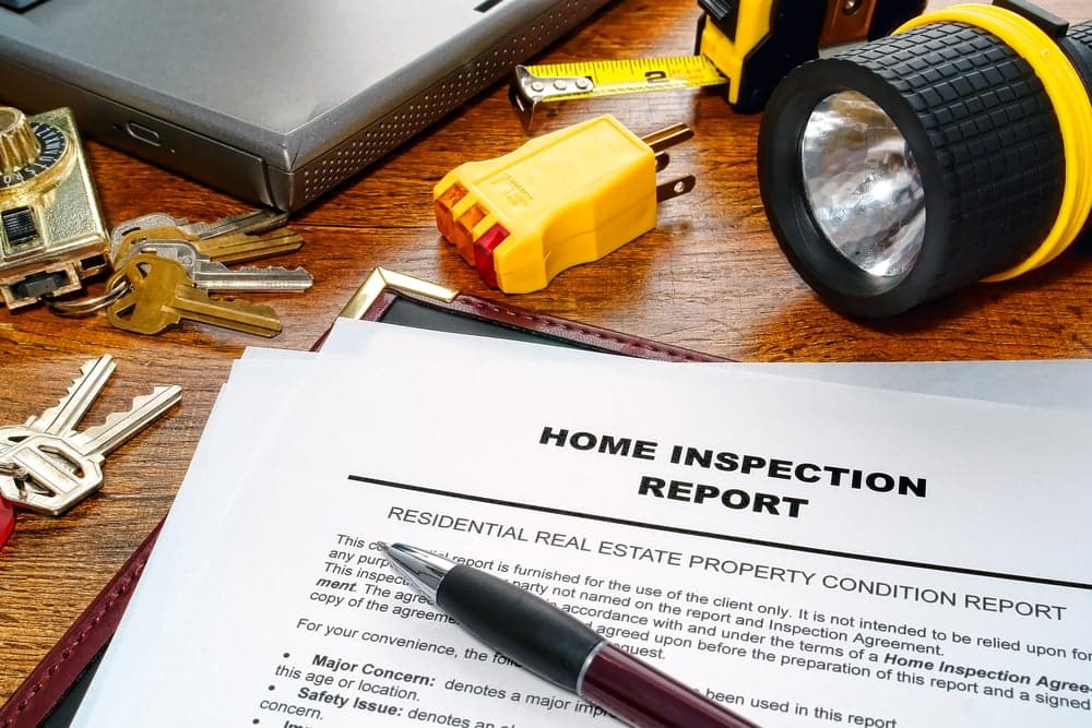 Home inspection report with tools on wooden desk
