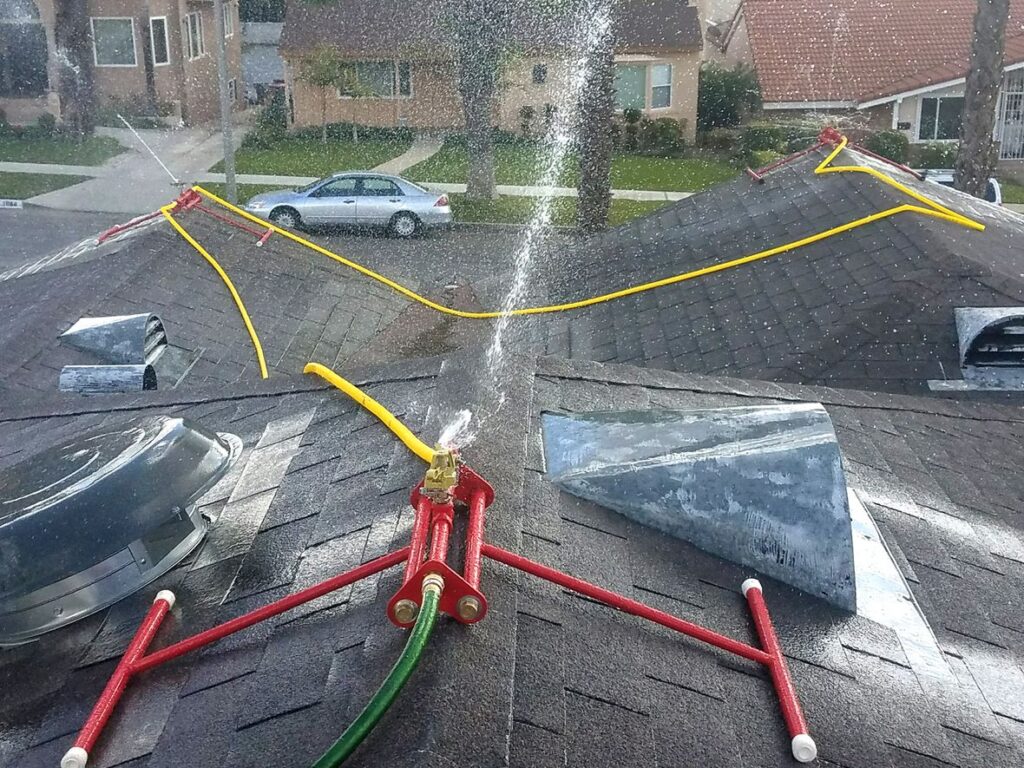 Roof sprinkler system activating for wildfire protection on residential home