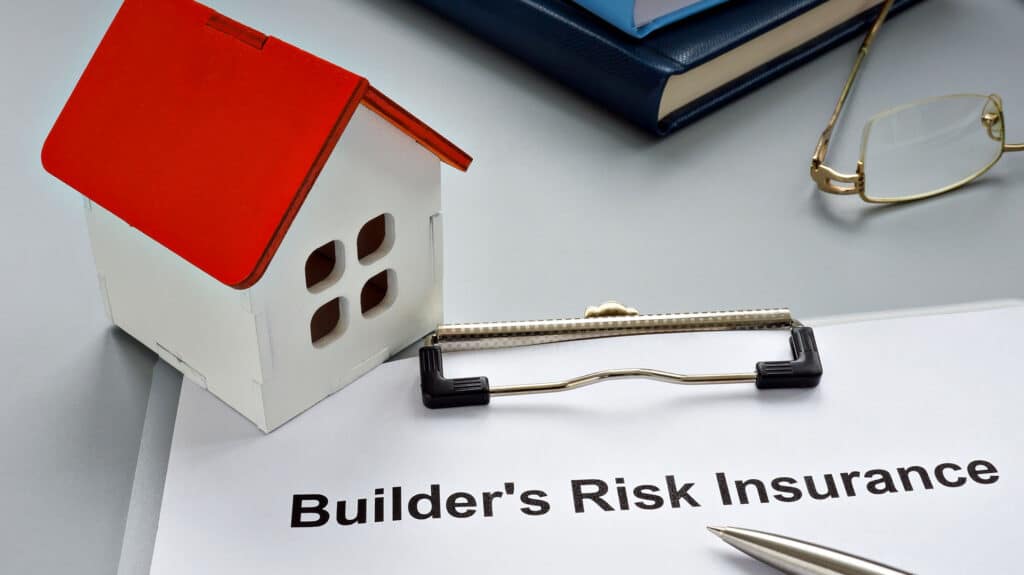 Model house and builder's risk insurance document on a desk