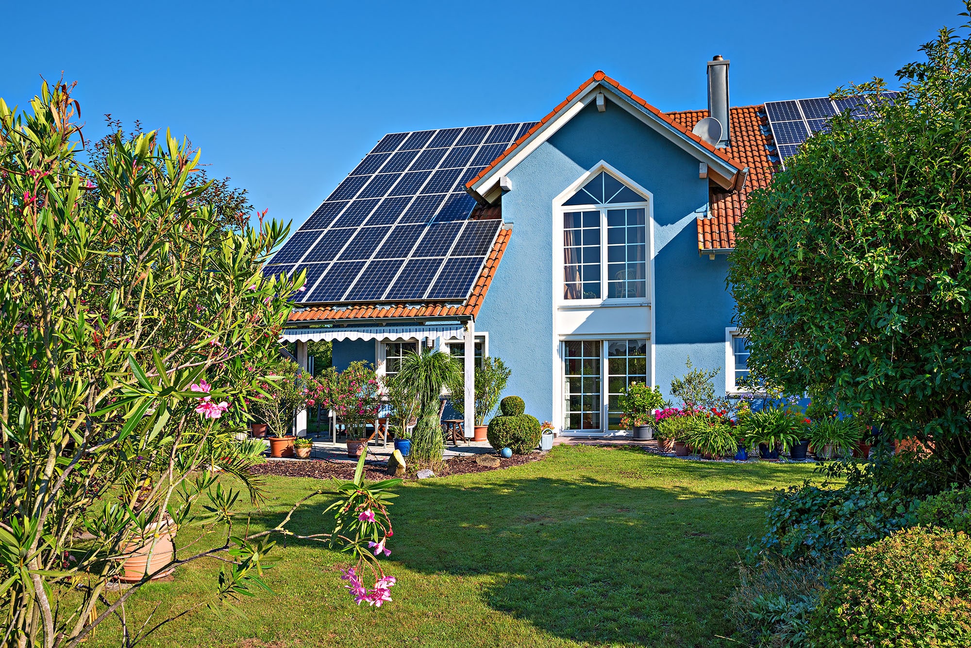Eco-friendly house with solar panels and lush garden