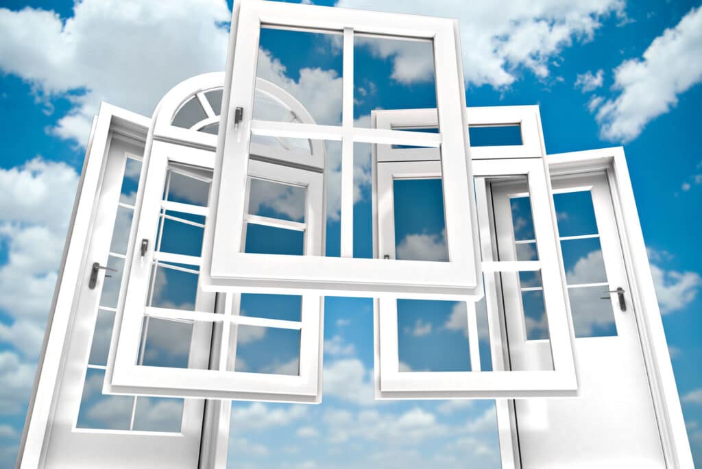 Floating white window frames against a blue sky with clouds
