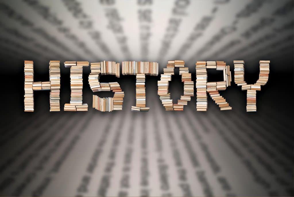 Books arranged to form the word 'History' against a blurred text background