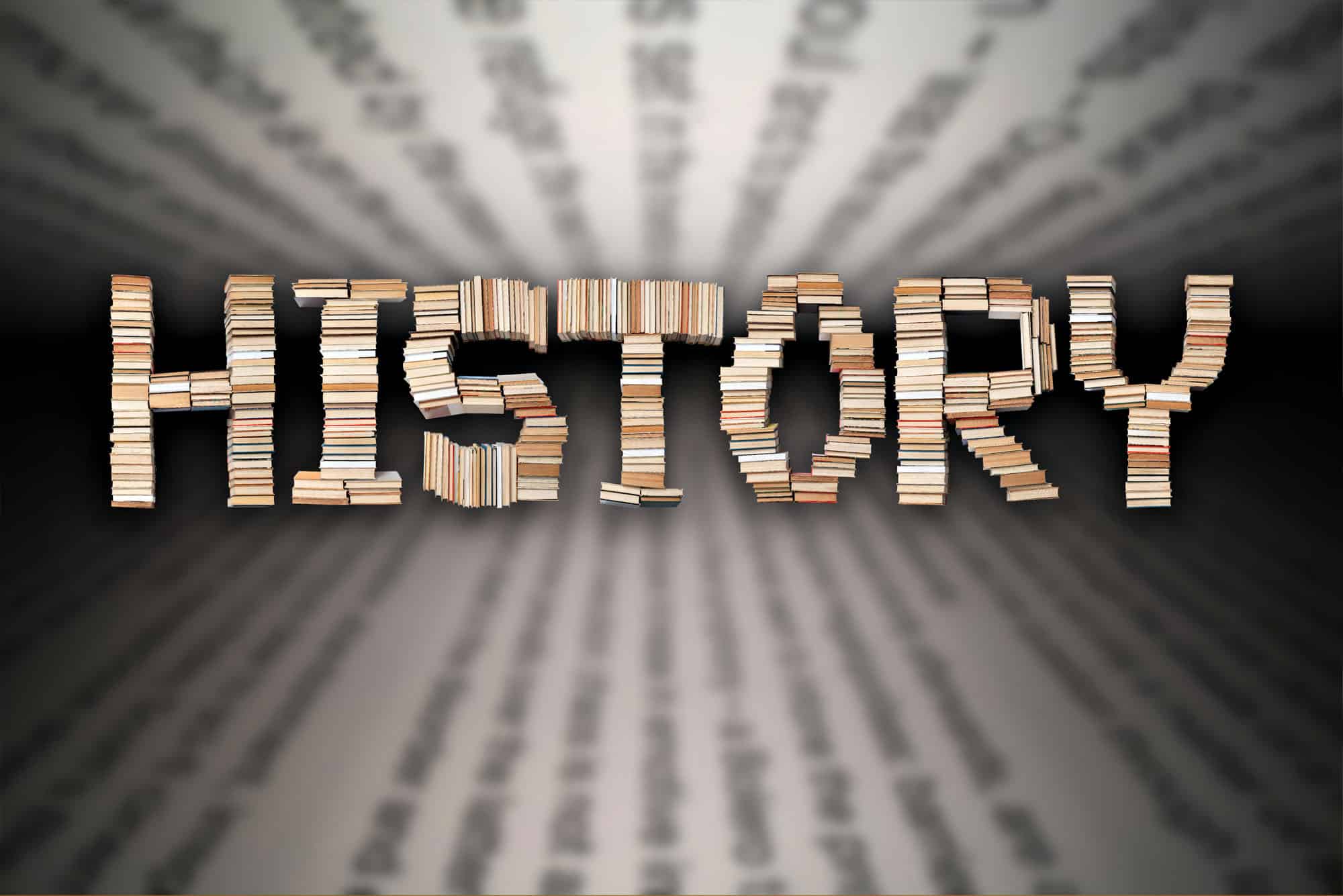 Books arranged to form the word 'History' against a blurred text background