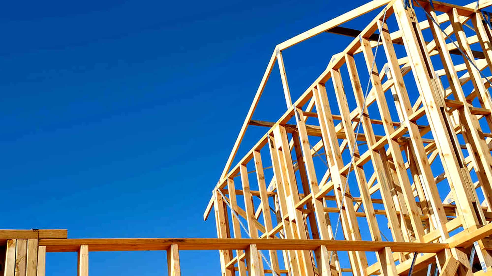 Wooden framing of a house under blue sky