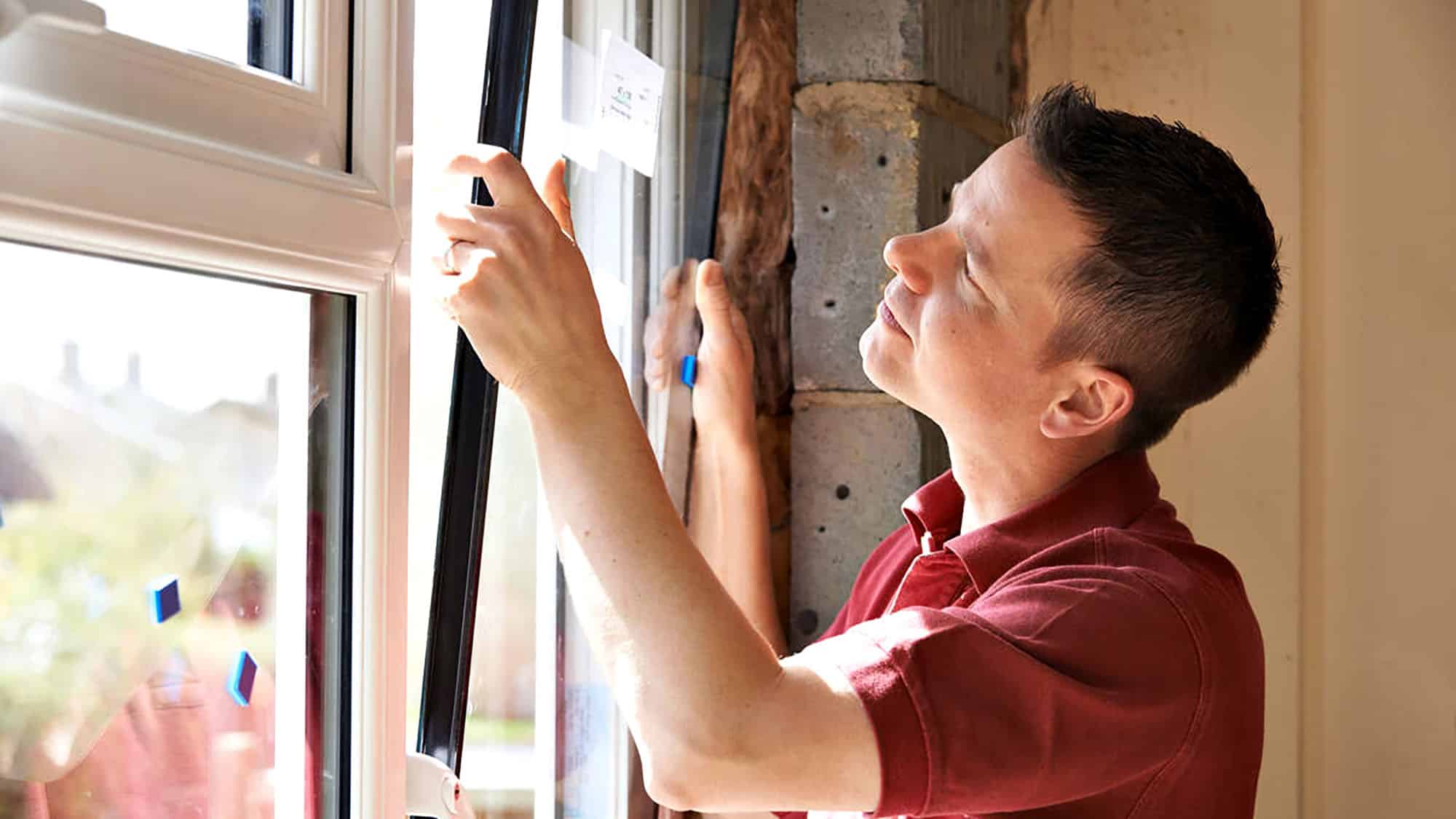 Man installing an energy-efficient window in a home construction project
