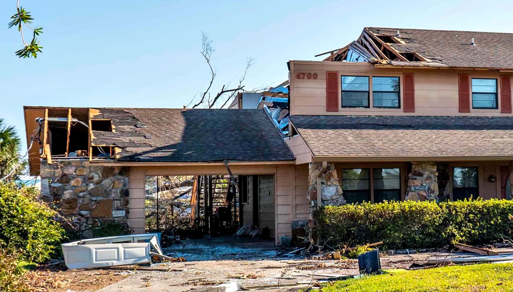 House with severe roof damage after a storm in a suburban neighbourhood
