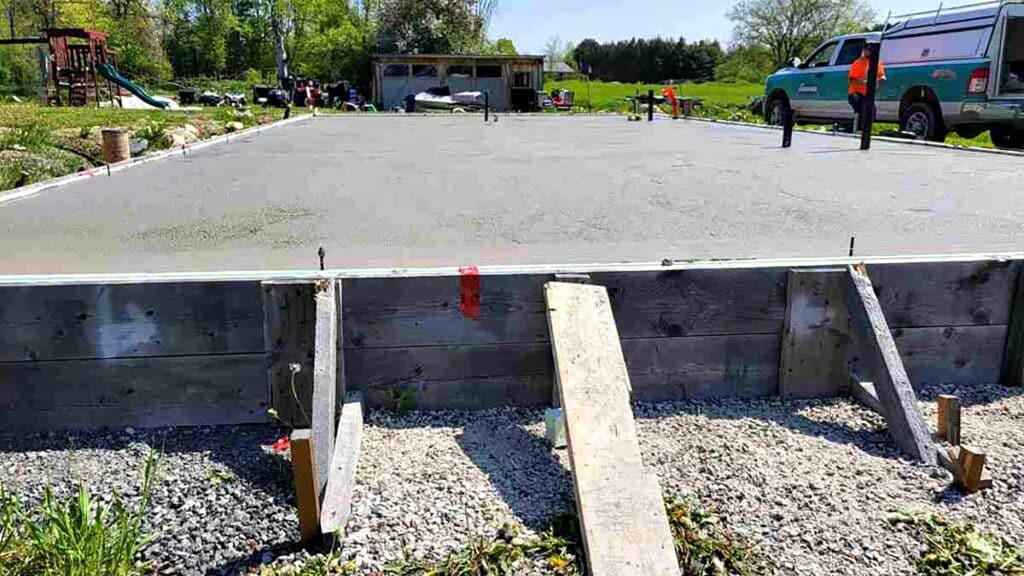 Freshly poured concrete slab foundation in garden area