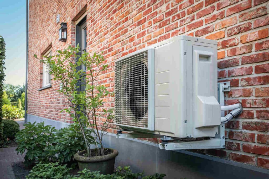 Outdoor air conditioning unit on red brick building facade