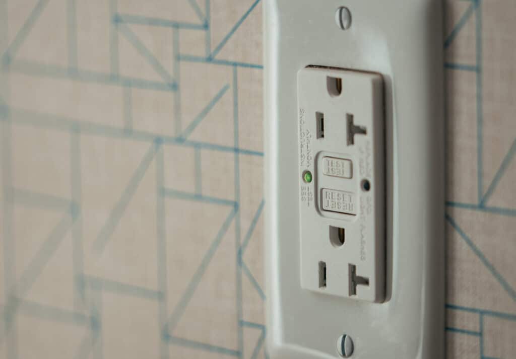 Wall outlet with built-in circuit breaker on patterned background