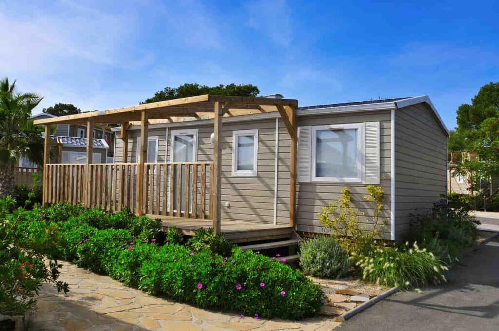 Modern mobile home with wooden deck and garden