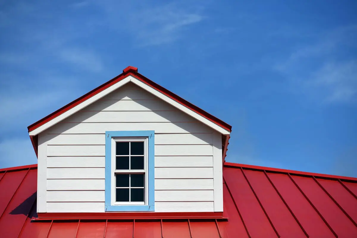 Red roof with dormer and blue sky background