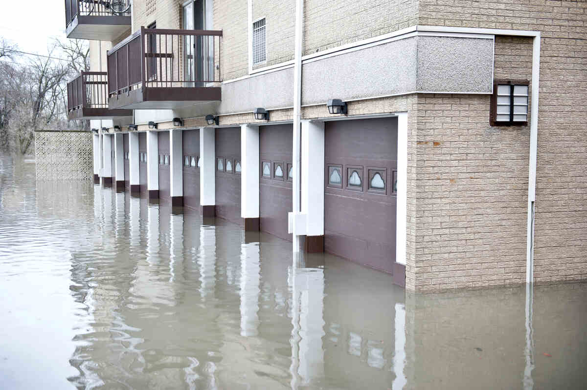 Flooded residential building with submerged garage doors