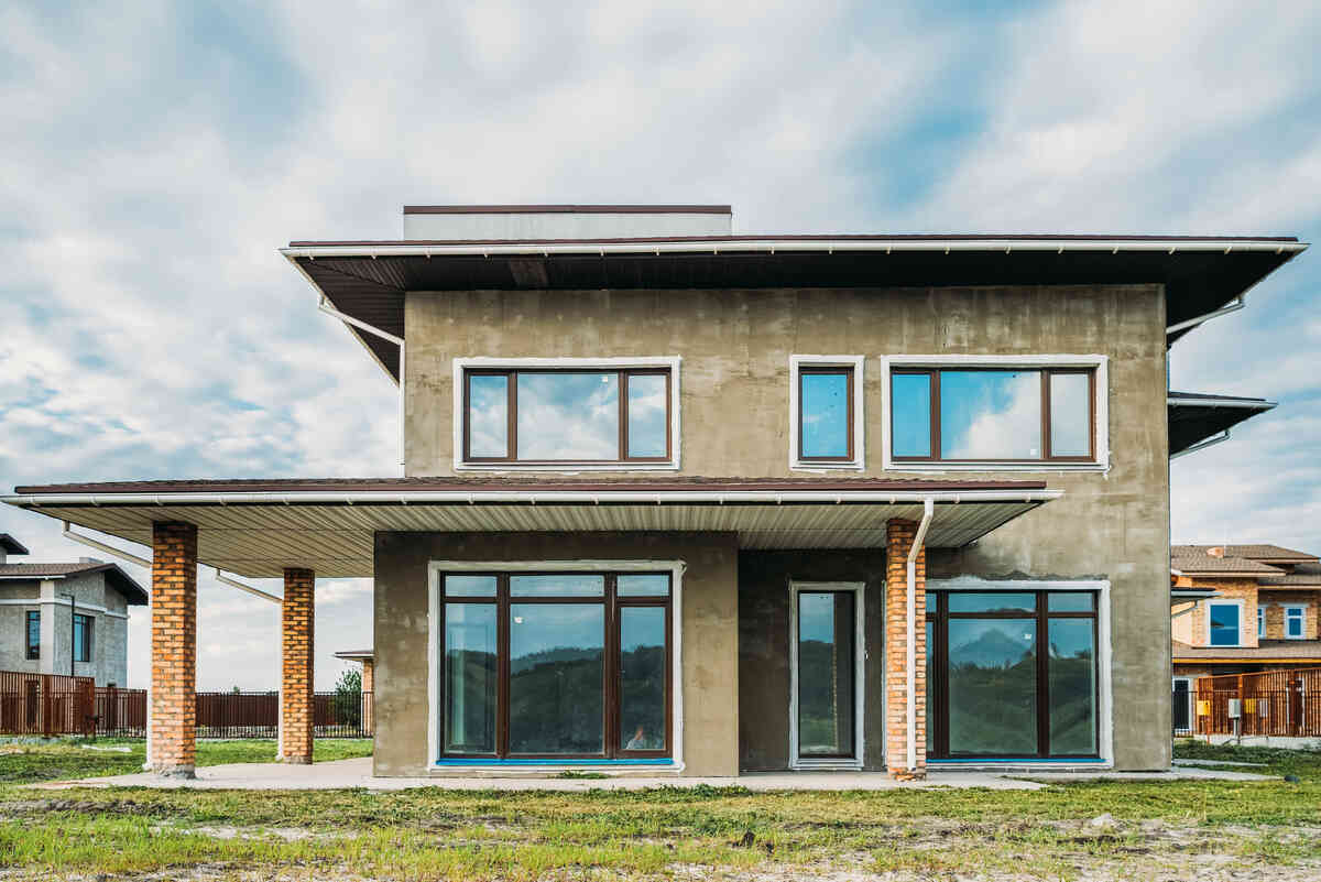 Modern two-storey house with large windows and brick accents