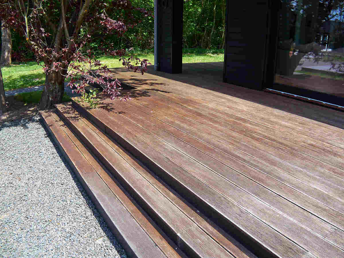 Wooden patio deck with stairs in a garden setting