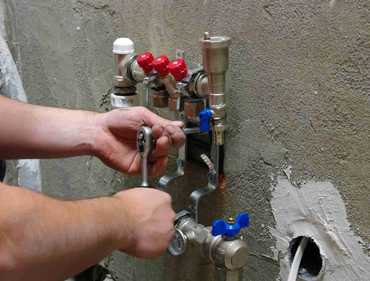 Plumber installing gas heating system valves