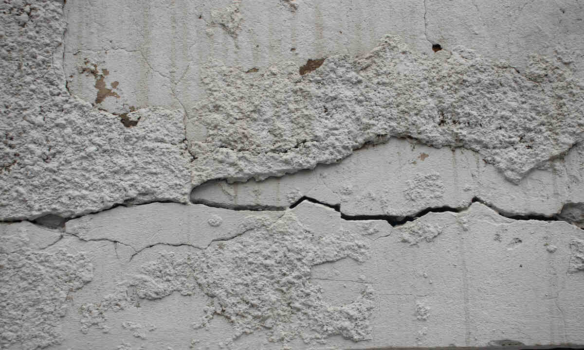 Cracked concrete wall with peeling paint texture