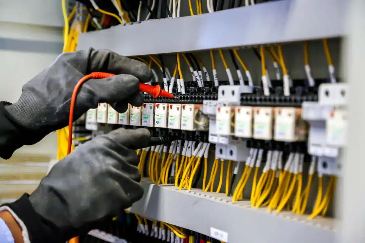 Electrician checks electrical panel with testing equipment