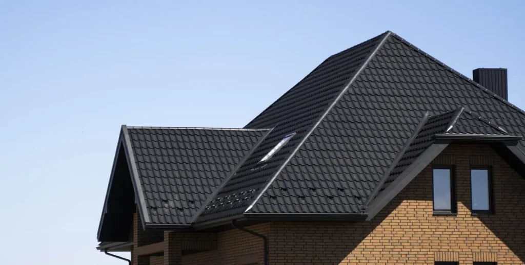 Modern house with black tile roof under clear blue sky