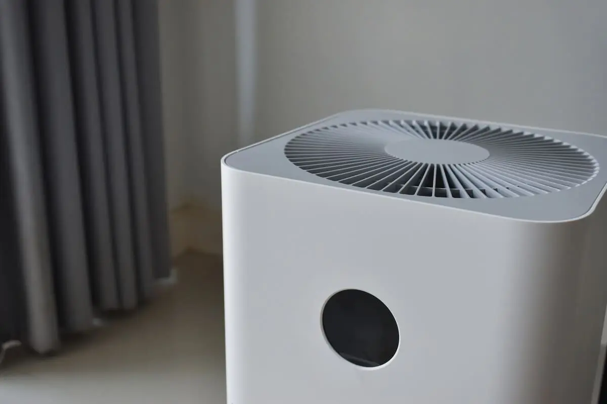 Modern grey air purifier in a room corner with sunlight