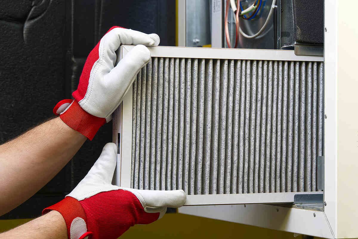 Technician replacing air filter in residential HVAC system