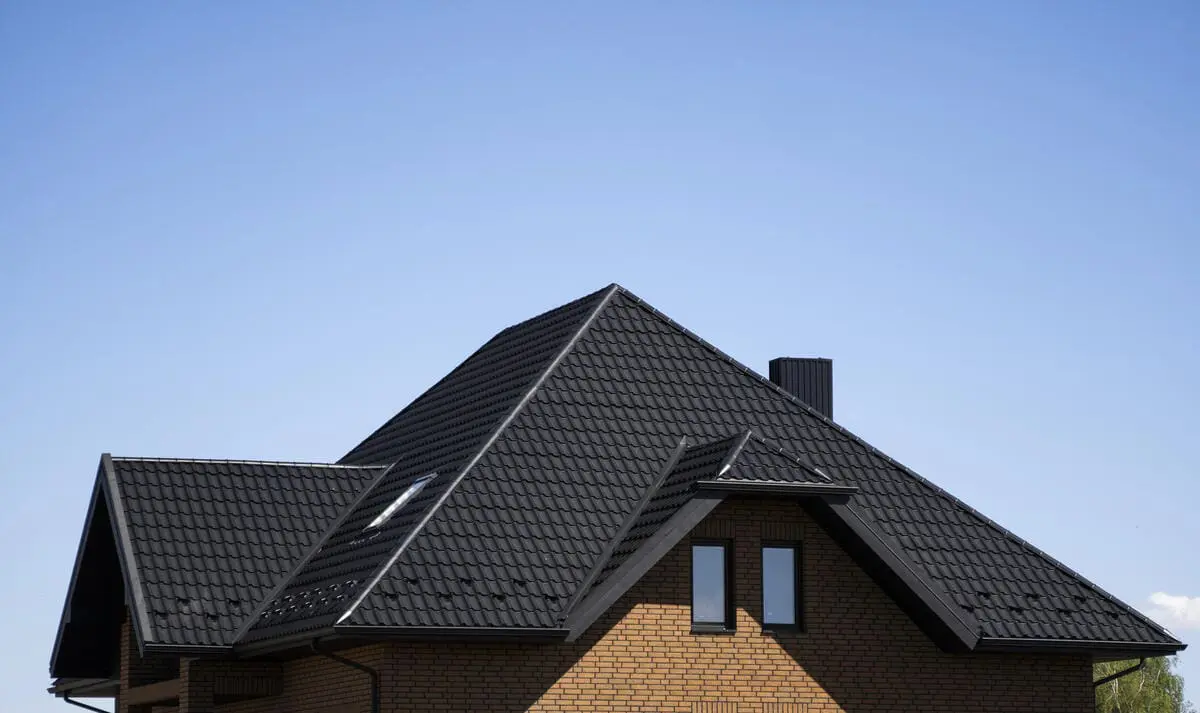 Modern house with dark shingle roof under clear blue sky