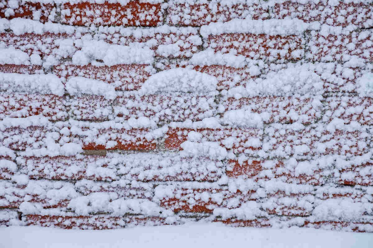 Brick wall covered in thick layer of snowflakes